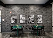 Thumbnail 12 of 30 - A black and white photo is on the wall above a table with a green tablecloth and two chairs.