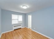 Thumbnail 5 of 10 - a bedroom with hardwood floors and blue walls