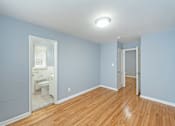 Thumbnail 6 of 10 - a bedroom with blue walls and a wooden floor