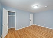 Thumbnail 7 of 10 - a bedroom with blue walls and a wooden floor
