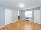 Thumbnail 9 of 10 - a bedroom with hardwood floors and blue walls