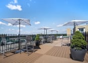 Thumbnail 23 of 30 - a roof top patio with tables and chairs and umbrellas