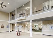 Thumbnail 4 of 11 - a large lobby with a ceiling fan and a balcony at Windsor Crossing Senior, Suitland, MD 20746 
