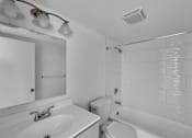 Thumbnail 3 of 15 - A white bathroom with a sink, toilet, and bathtub.
