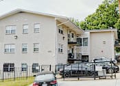 Thumbnail 1 of 6 - a picture of a three story apartment building with a black car parked in front of it