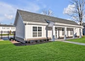 Thumbnail 8 of 15 - A small house with a grey roof and white walls.