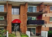 Thumbnail 1 of 6 - a building with a red awning in front of it