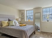 Thumbnail 4 of 10 - A bedroom with a large bed and a window with blinds at Dutch Village Apartments, Baltimore, MD, 21234