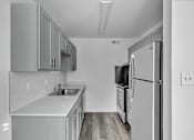 Thumbnail 2 of 15 - A kitchen with a refrigerator, sink, and cabinets.