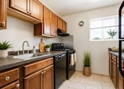 Thumbnail 3 of 38 - A kitchen with black appliances and wooden cabinets.