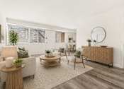 Thumbnail 5 of 46 - A living room with a white sofa, a wooden coffee table, and a white chair.