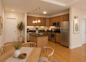 Thumbnail 4 of 10 - A modern kitchen with wooden cabinets and stainless steel appliances.