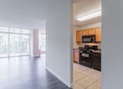 Thumbnail 26 of 29 - A kitchen with black appliances and wooden cabinets at Charlestowne North Apartments, Greenbelt, MD