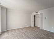 Thumbnail 21 of 29 - A room with a carpeted floor and a doorway leading to another room at Charlestowne North Apartments, Greenbelt, MD