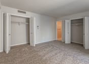 Thumbnail 20 of 29 - A room with white walls and carpeted floor with four open closets at Charlestowne North Apartments, Greenbelt, MD