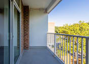 Thumbnail 13 of 29 - A balcony with a glass door and a metal railing at Charlestowne North Apartments, Greenbelt, Maryland