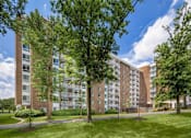 Thumbnail 10 of 29 - A large apartment building with a green lawn in front at Charlestowne North Apartments, Maryland, 20770