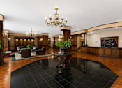 Thumbnail 6 of 17 - A large room with a black table in the middle and a chandelier hanging from the ceiling.