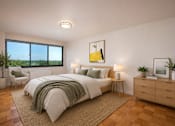 Thumbnail 9 of 18 - A bedroom with a large bed, a chair, a nightstand, and a window overlooking the ocean.