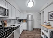 Thumbnail 16 of 49 - Kitchen with white cabinets and a stainless steel refrigerator at Columbia Pointe, Maryland , 21045