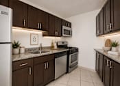 Thumbnail 4 of 14 - A kitchen with brown cabinets and a white refrigerator.