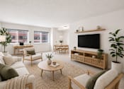 Thumbnail 2 of 14 - A living room with a white couch, a wooden coffee table, and a flat-screen TV.