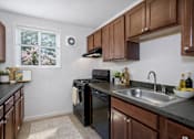 Thumbnail 5 of 19 - A kitchen with black appliances and wooden cabinets.