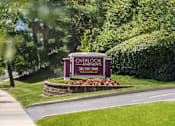 Thumbnail 15 of 23 - A sign for Overlook Apartments is displayed in front of a green hedge.