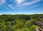 Thumbnail 9 of 29 - A serene landscape with a building, trees, and a river at Charlestowne North Apartments, Greenbelt