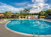 Thumbnail 5 of 29 - A large outdoor swimming pool with a yellow umbrella at Charlestowne North Apartments, Greenbelt, Maryland