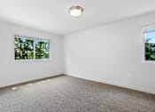 Thumbnail 11 of 19 - A room with a carpeted floor and two windows.