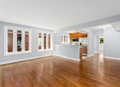 Thumbnail 4 of 14 - an empty living room with a kitchen in the background