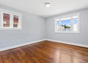 Thumbnail 6 of 14 - a bedroom with hardwood floors and two windows