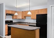Thumbnail 6 of 6 - a kitchen with wooden cabinets and black appliances