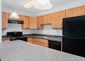 Thumbnail 3 of 6 - a kitchen with granite countertops and black appliances