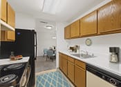 Thumbnail 2 of 15 - kitchen at Creekside at Taskers Chance in Frederick, MD with black appliances, wood cabinets and white countertops
