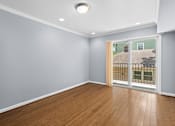 Thumbnail 5 of 6 - a bedroom with a sliding glass door and hardwood floors