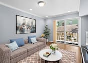 Thumbnail 10 of 14 - a living room with a gray couch and a white coffee table with a vase of flowers