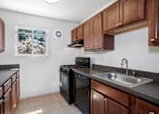 Thumbnail 13 of 19 - A kitchen with brown cabinets and a black stove top oven.