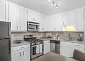 Thumbnail 1 of 17 - Modern Kitchen With Stainless Steel Appliances And Double Door Refrigerators at Versailles Apartments, Towson, 21204