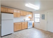Thumbnail 3 of 10 - A kitchen with wooden cabinets and a white refrigerator at Dutch Village Apartments, Baltimore, 21234