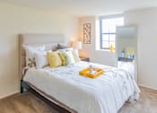Thumbnail 7 of 10 - A bedroom with a large bed and a mirror on the wall at Dutch Village Apartments, Maryland