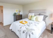 Thumbnail 6 of 10 - A bedroom with a large bed and a nightstand with a lamp at Dutch Village Apartments, Baltimore