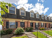 Thumbnail 1 of 10 - A row of houses with black shutters and red doors at Dutch Village Apartments, Baltimore, 21234