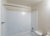 Thumbnail 8 of 10 - A white bathroom with a toilet, sink, and bathtub at Dutch Village Apartments, Baltimore, MD
