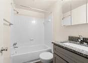 Thumbnail 19 of 46 - A white bathroom with a toilet, sink, and bathtub at Seven Springs Apartments, College Park