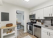Thumbnail 12 of 49 - Modern kitchen with stainless steel appliances and white cabinets at Columbia Pointe, Columbia, Maryland 