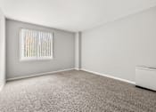 Thumbnail 18 of 41 - A room with a carpeted floor and a window with blinds.