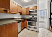 Thumbnail 29 of 41 - A kitchen with wooden cabinets and stainless steel appliances.