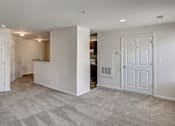 Thumbnail 3 of 17 - an empty living room and kitchen with white doors at Windsor Crossing, Suitland, MD 20746 